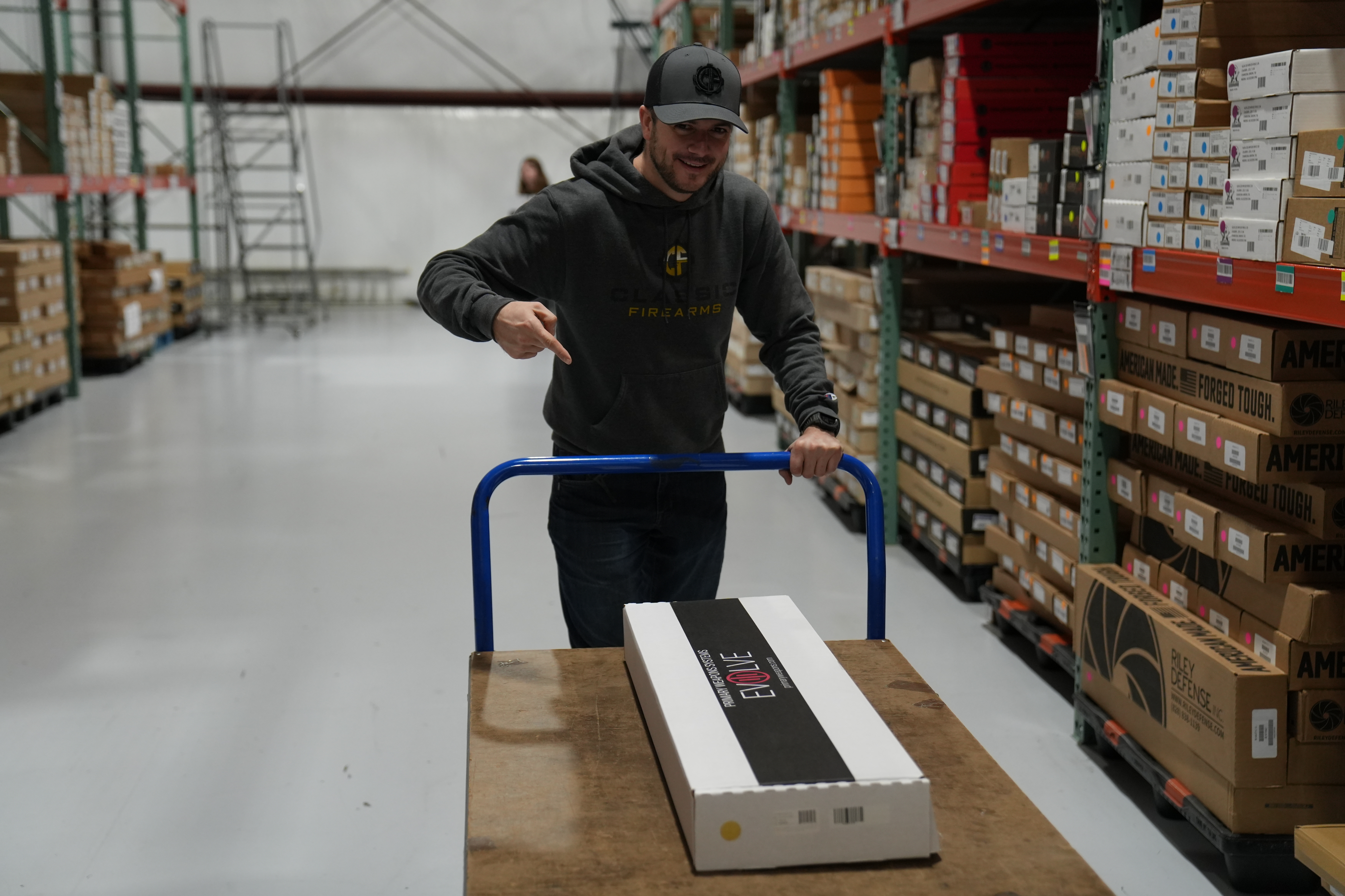 Clint pushing a cart with his selected firearm